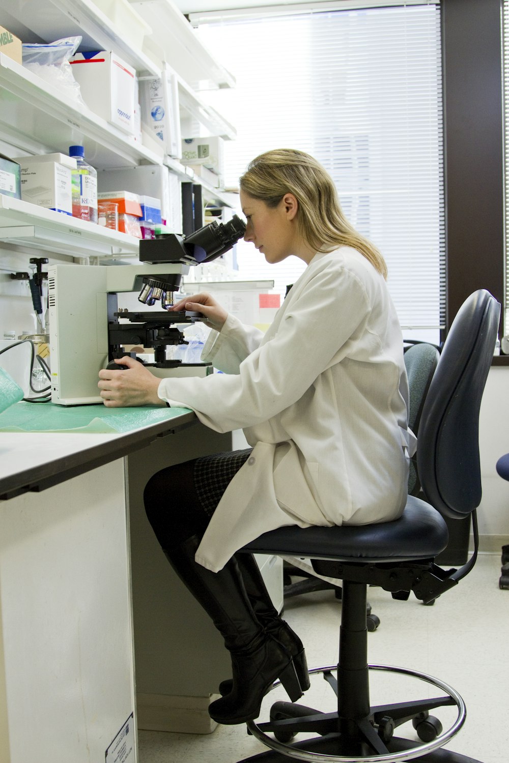 Researcher examining samples under a microscope in a laboratory