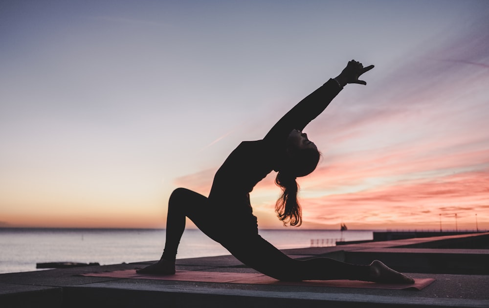 Person practicing yoga at sunrise for healthy lifestyle